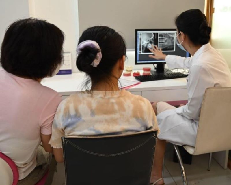 Bác sĩ của nha khoa đang tư vấn phụ huynh về phác đồ chỉnh nha cho trẻ